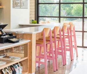 Sadie II Barstool in pink and natural at a modern coffee shop