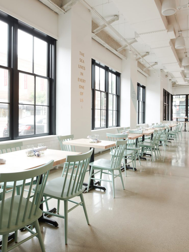 Row of mind green Hugh Chairs in restaurant.