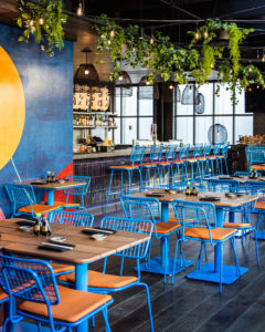 Bowen pedestal tables with blue base in restaurant.
