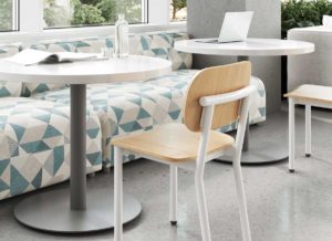 Modern Dining Chair with White Frame and Natural wood seat and back in a university cafeteria at a table.
