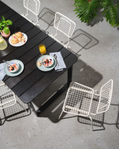 Overhead view of the bowen outdoor dining table with white Opla chairs
