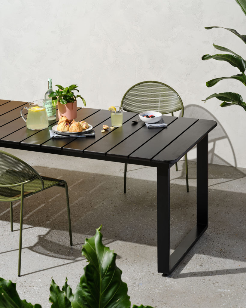Black outdoor dining table with olive green outdoor stacking chairs