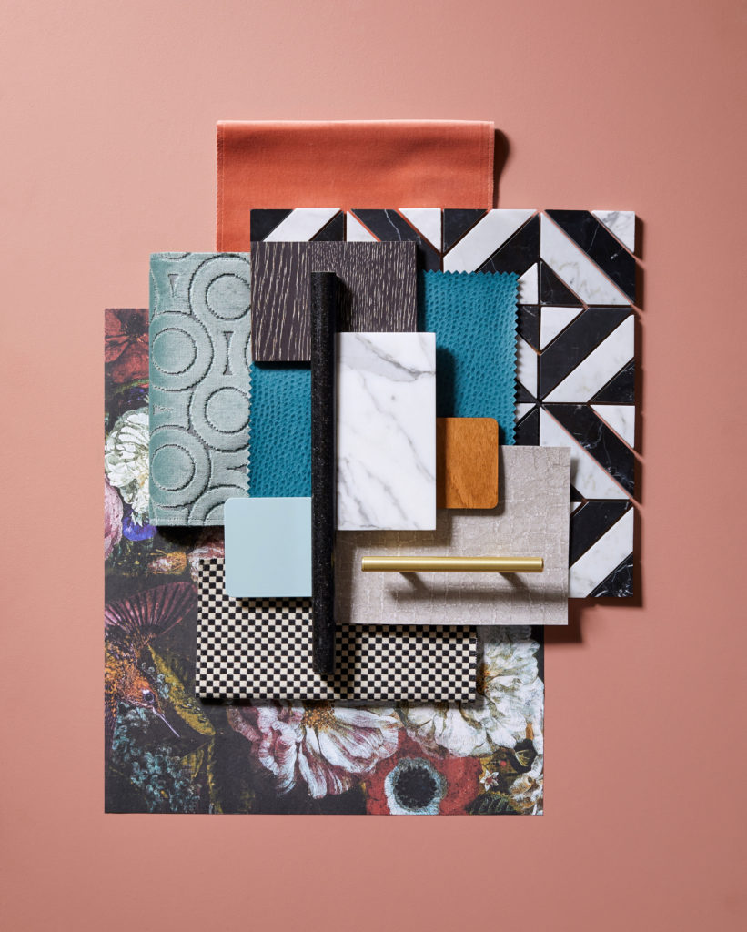 Flat lay of many materials on a peach backdrop including our dusty blue metal finish. Lots of pattern, texture.
