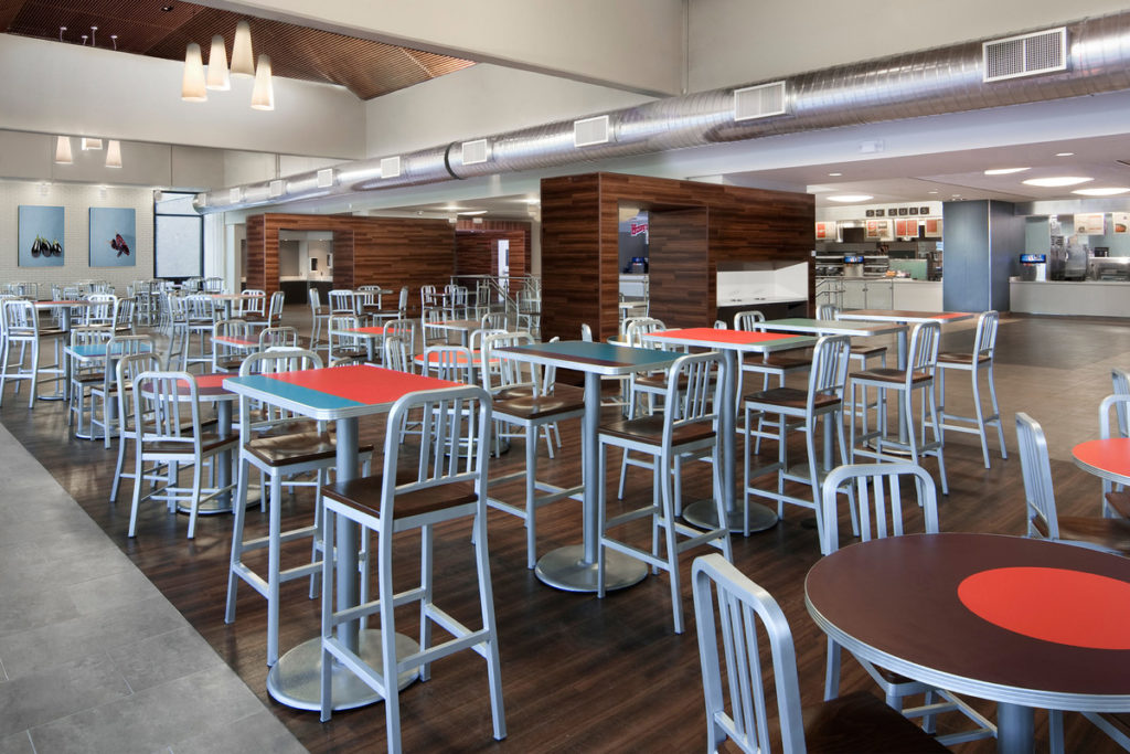Aluminum Siren Barstools with wood seat in cafe setting.