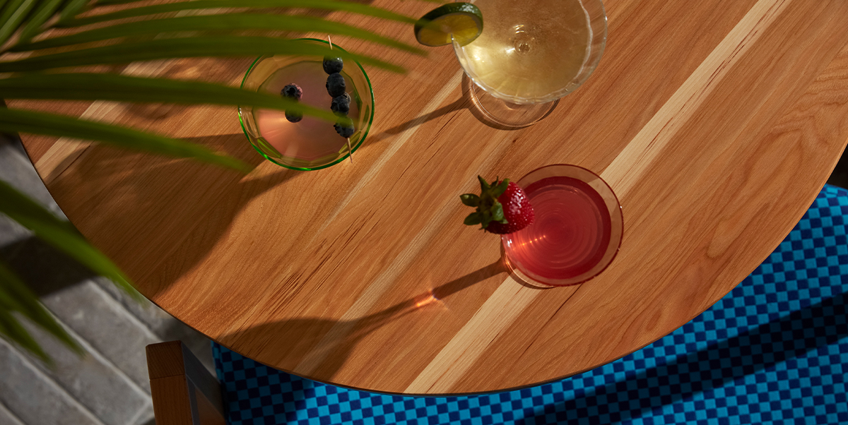 Aerial view of round wood table with cocktails.