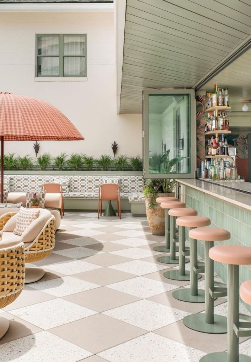 Outdoor bar and lounge with set of green and pink Sally Freestanding Stools.