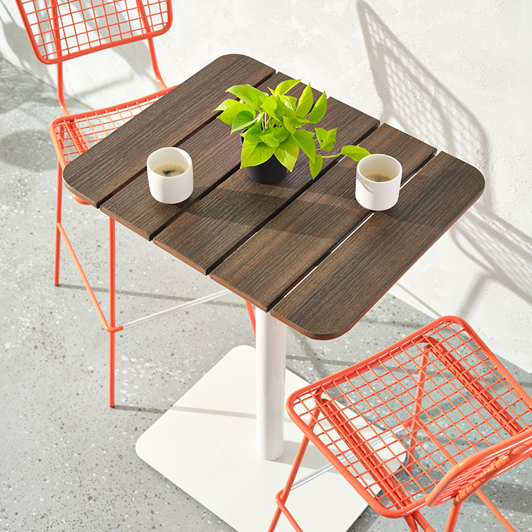 Pair of Bowen Pedestal Tables with orange Opla Stools.