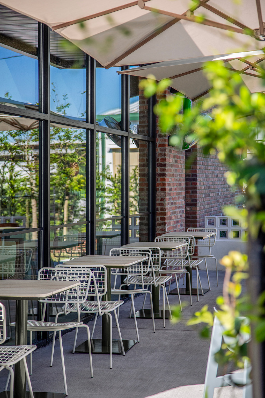 Opla Outdoor Chairs paired with Bowen Outdoor Pedestal table on a restaurant patio