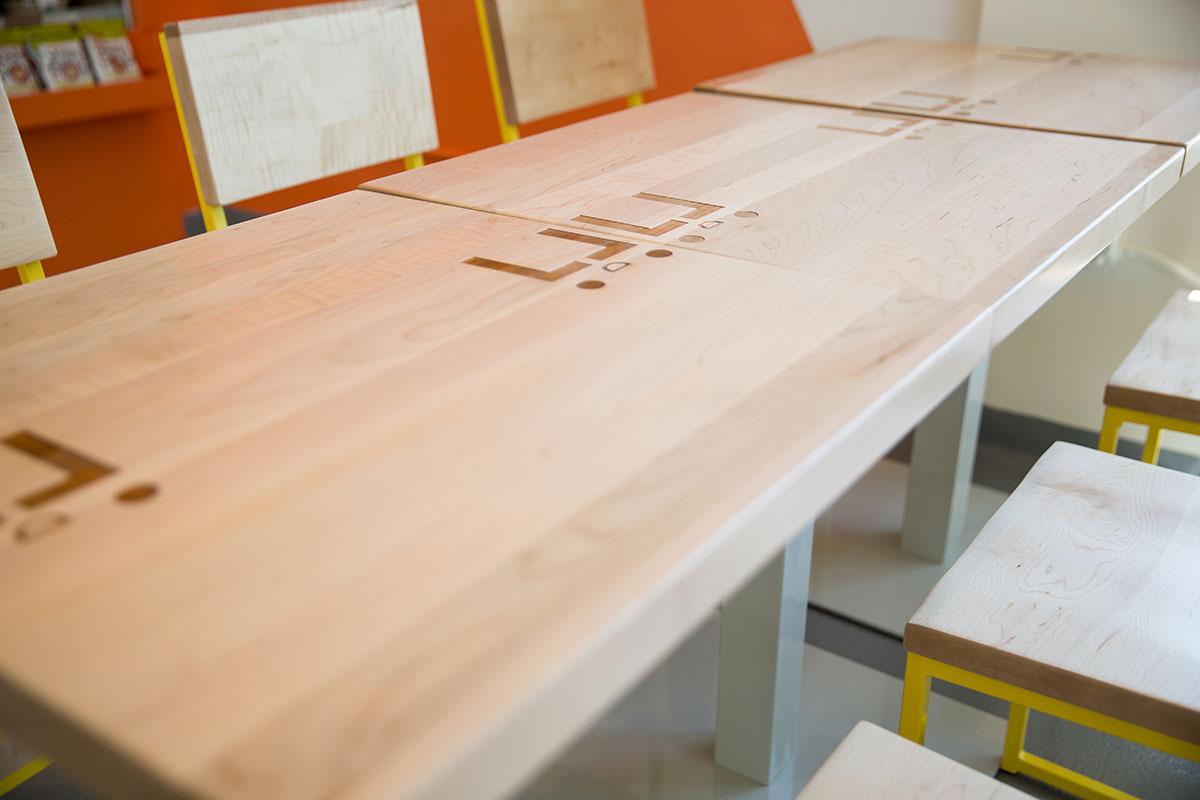 Solid maple tabletops, engraved with Everytable logos and left unfilled, let the natural beauty of the wood take center stage.