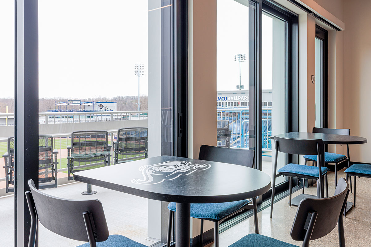 A D-Shaped Onesima Pedestal Table, now with a home-run twist: the LMCU Ballpark logo, engraved right into the laminate and backfilled in crisp white. Photo by Carbon Stories. 